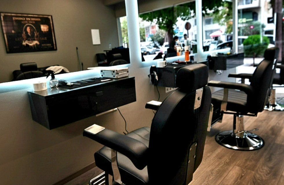 Το εσωτερικό του BK HAIR STUDIO: δύο μαύρες καρέκλες barber, ο φωτισμένος καθρέφτης και το ξύλινο πάτωμα